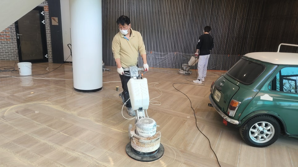 미니쿠퍼 배경으로 작업자가 연마 작업 중
