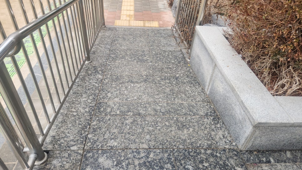 야외 통로 난간이 있는 매끈한 화강석 바닥